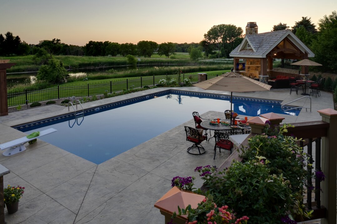 Backyard pool with seating at sunset