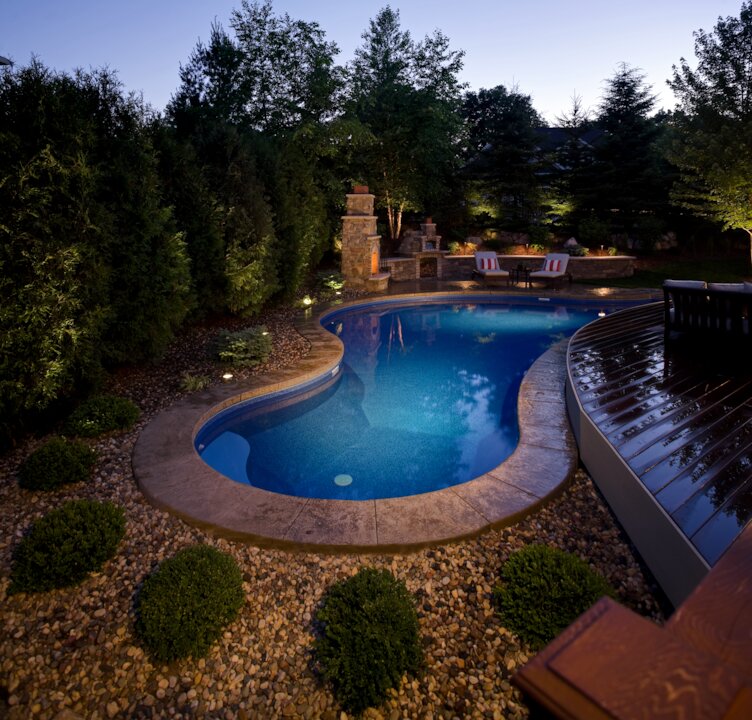 Elegant backyard pool with night lighting.