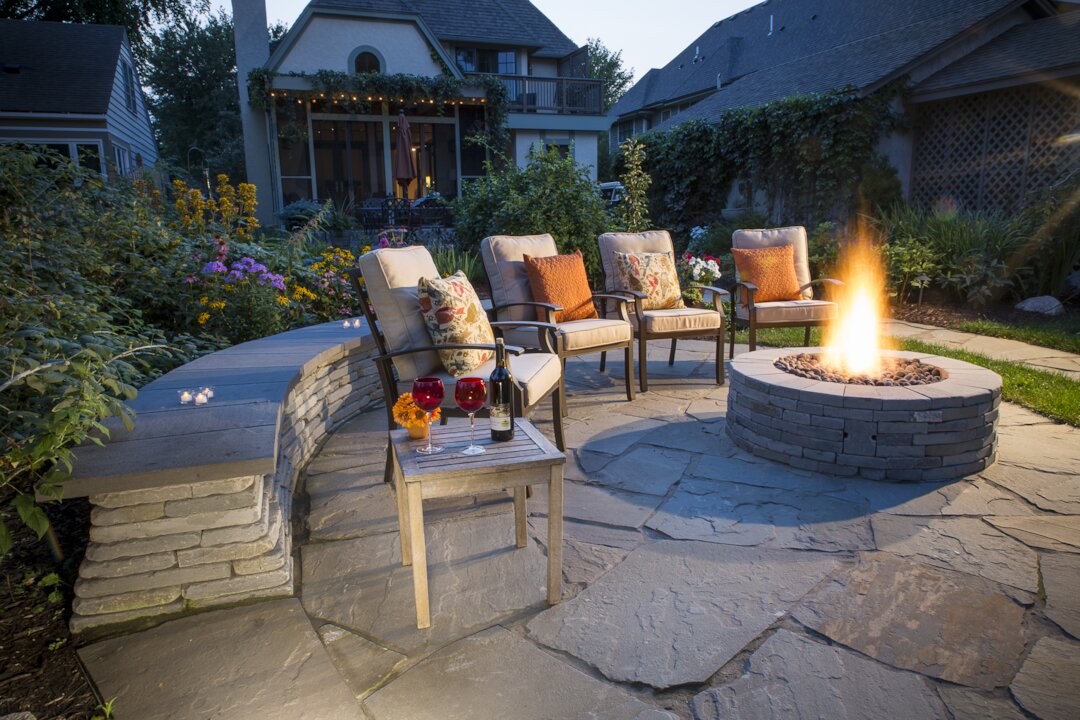 Cozy patio with fire pit and chairs.