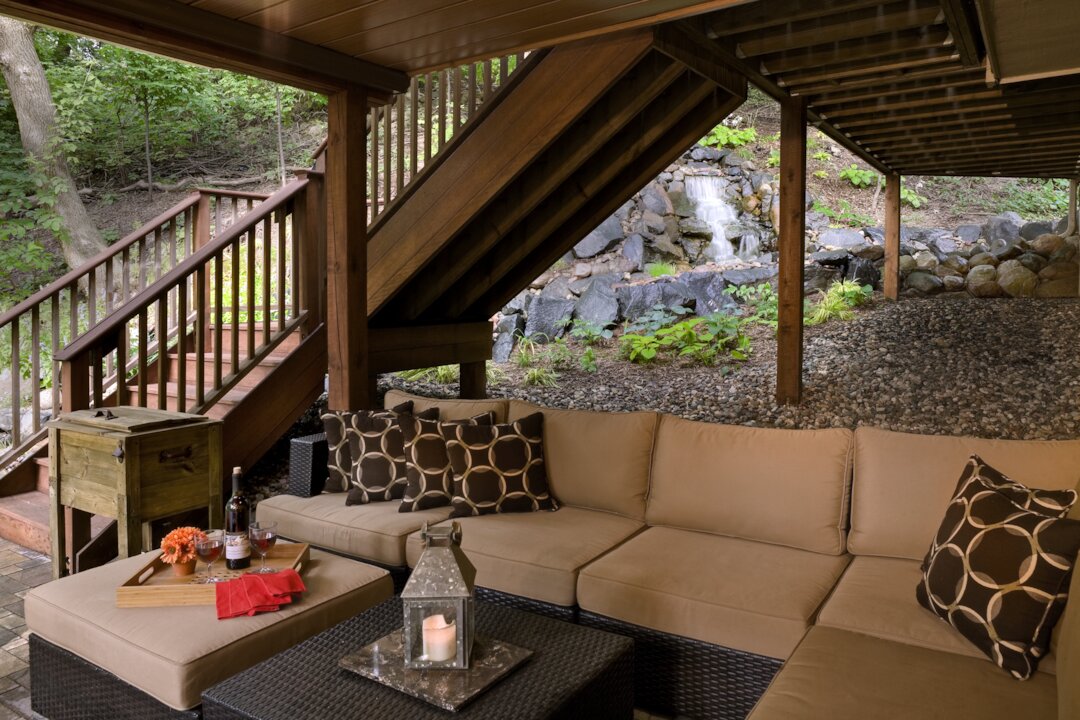 Cozy patio with seating and waterfall view.