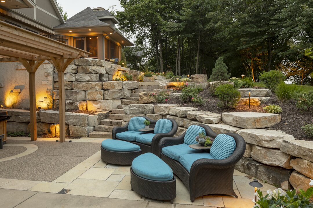 Outdoor patio with stone walls and blue seating.