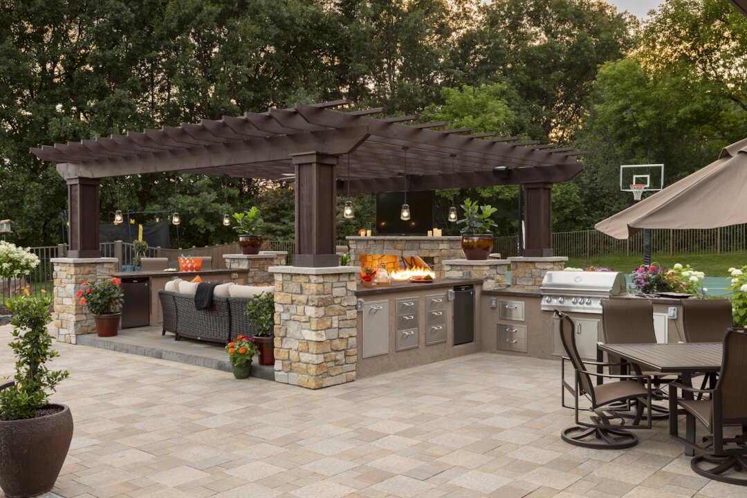Outdoor kitchen with grill and seating area.
