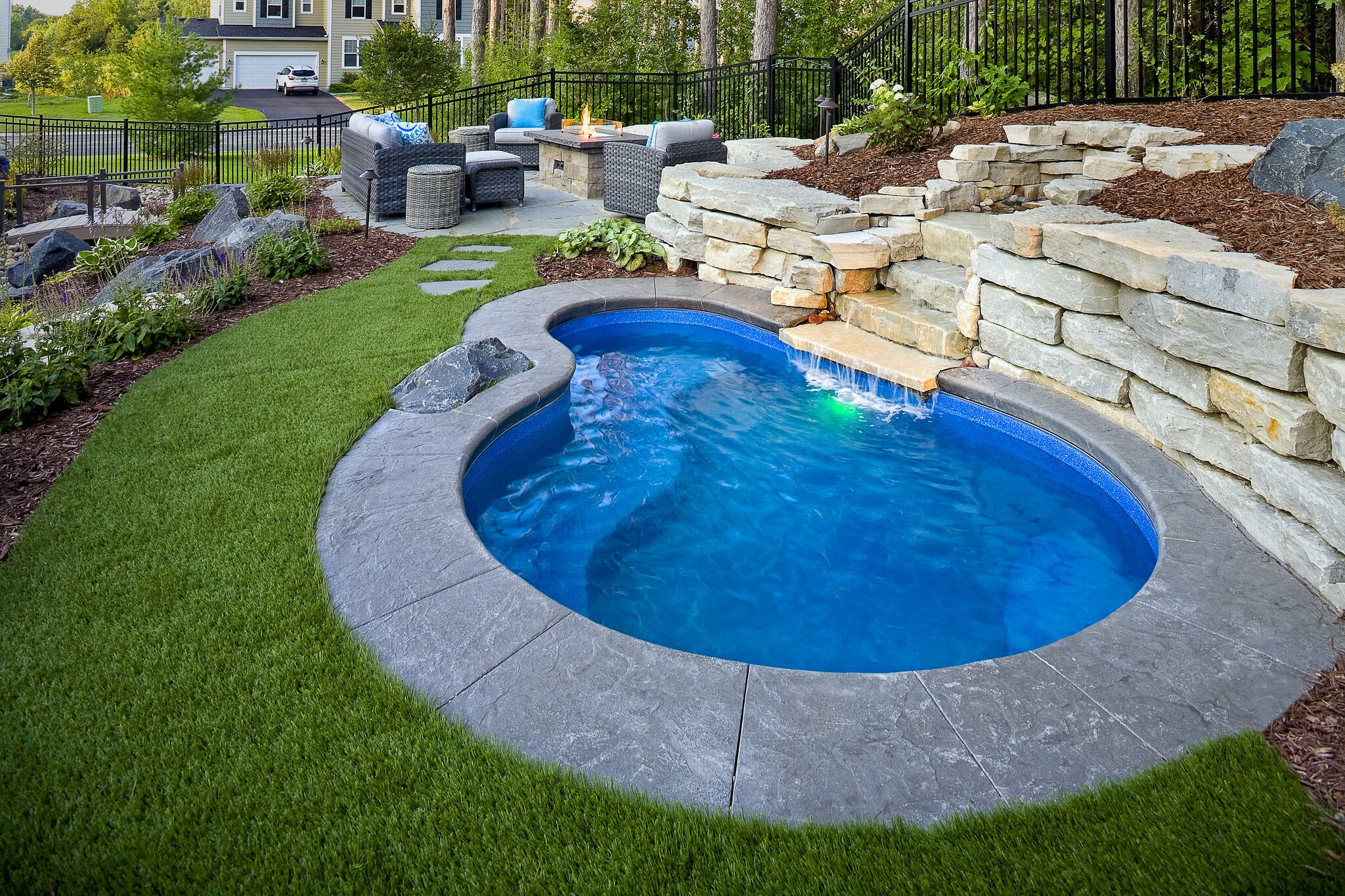 Backyard with small pool and seating area.