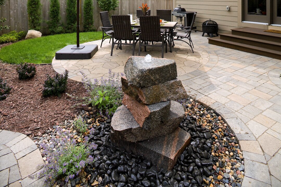 Backyard patio with stacked stone water feature