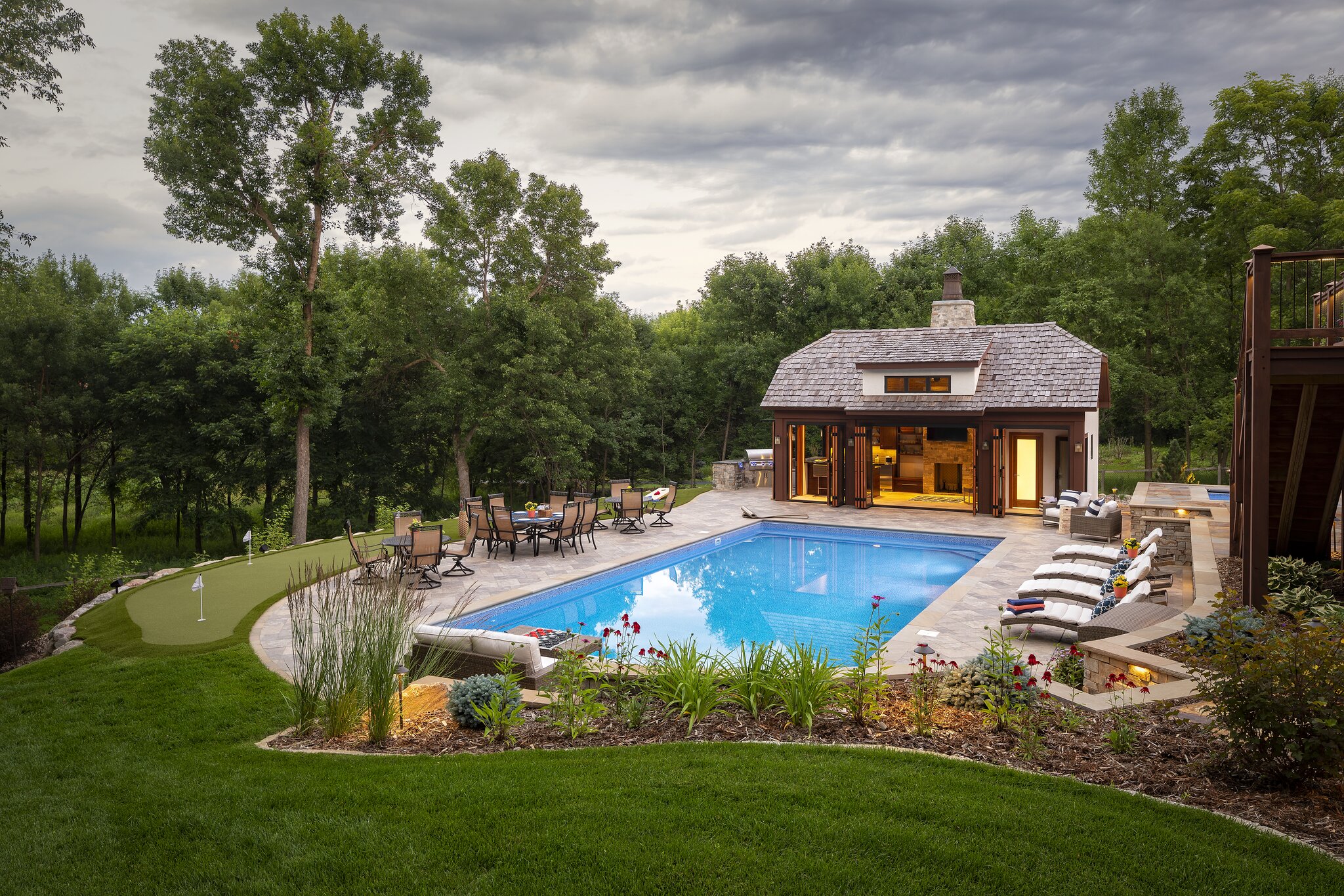 Backyard pool with patio and trees.