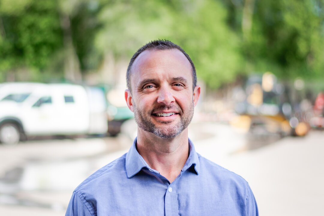 Smiling man outdoors in a blue shirt