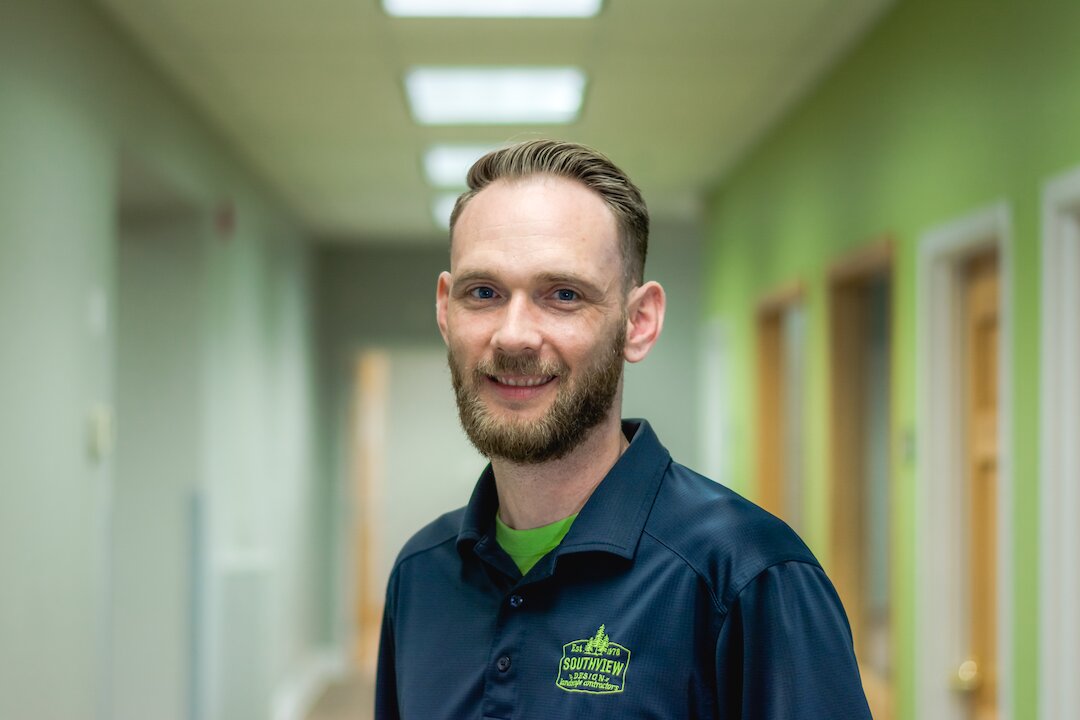 Smiling man in blue shirt in office hallway