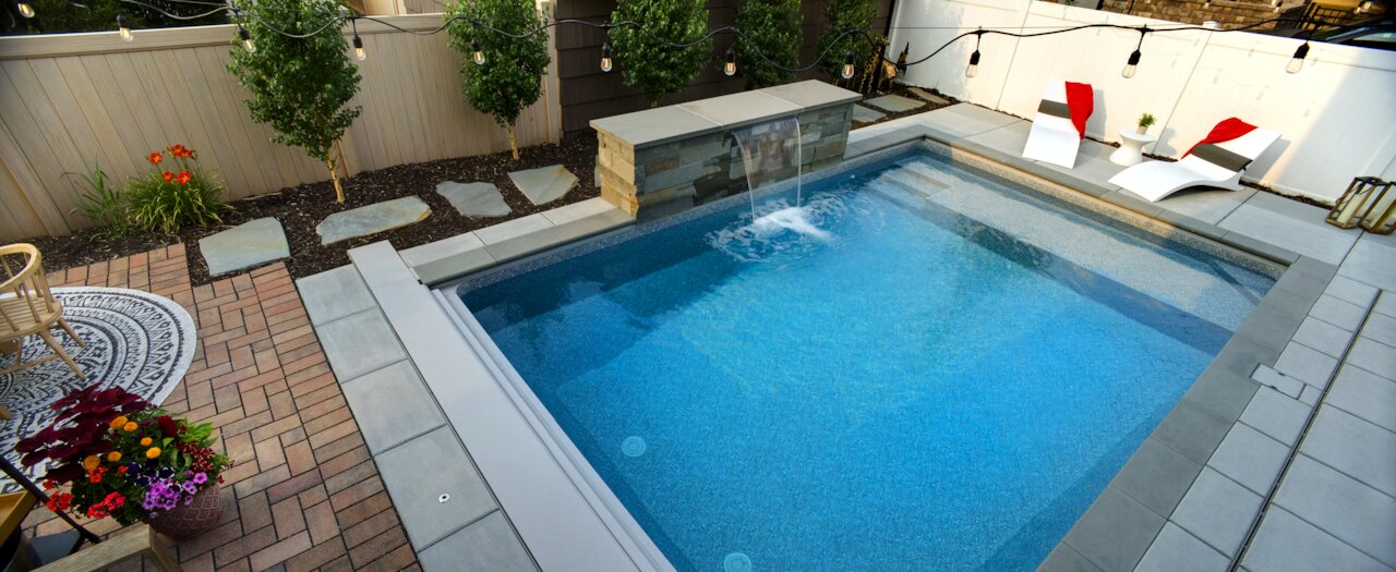 Modern backyard with pool and lounge chairs.