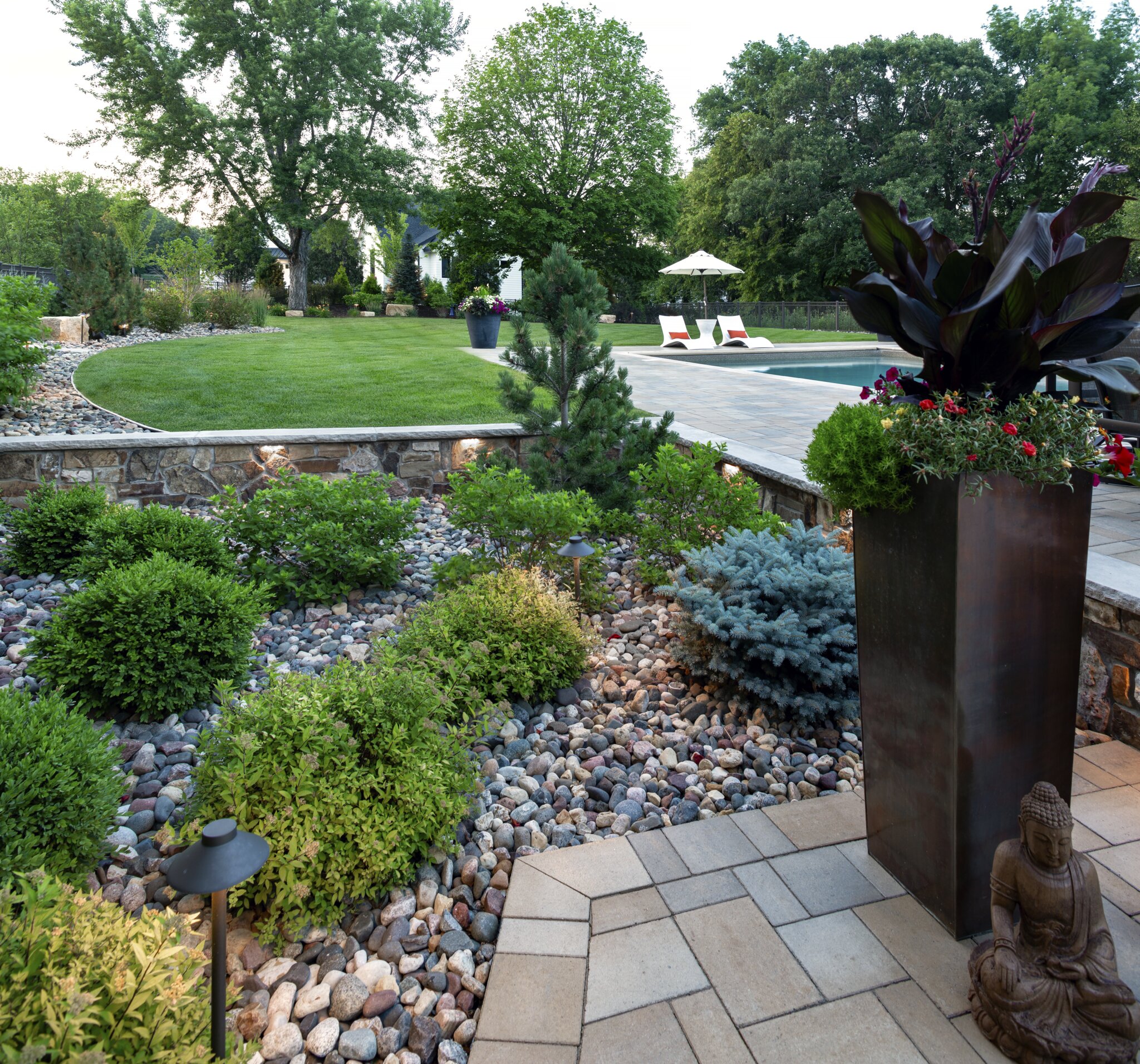 Beautiful landscaped backyard with statue and pool