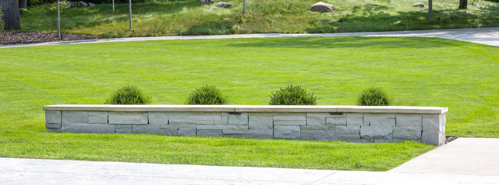 Manicured lawn with stone border and trees