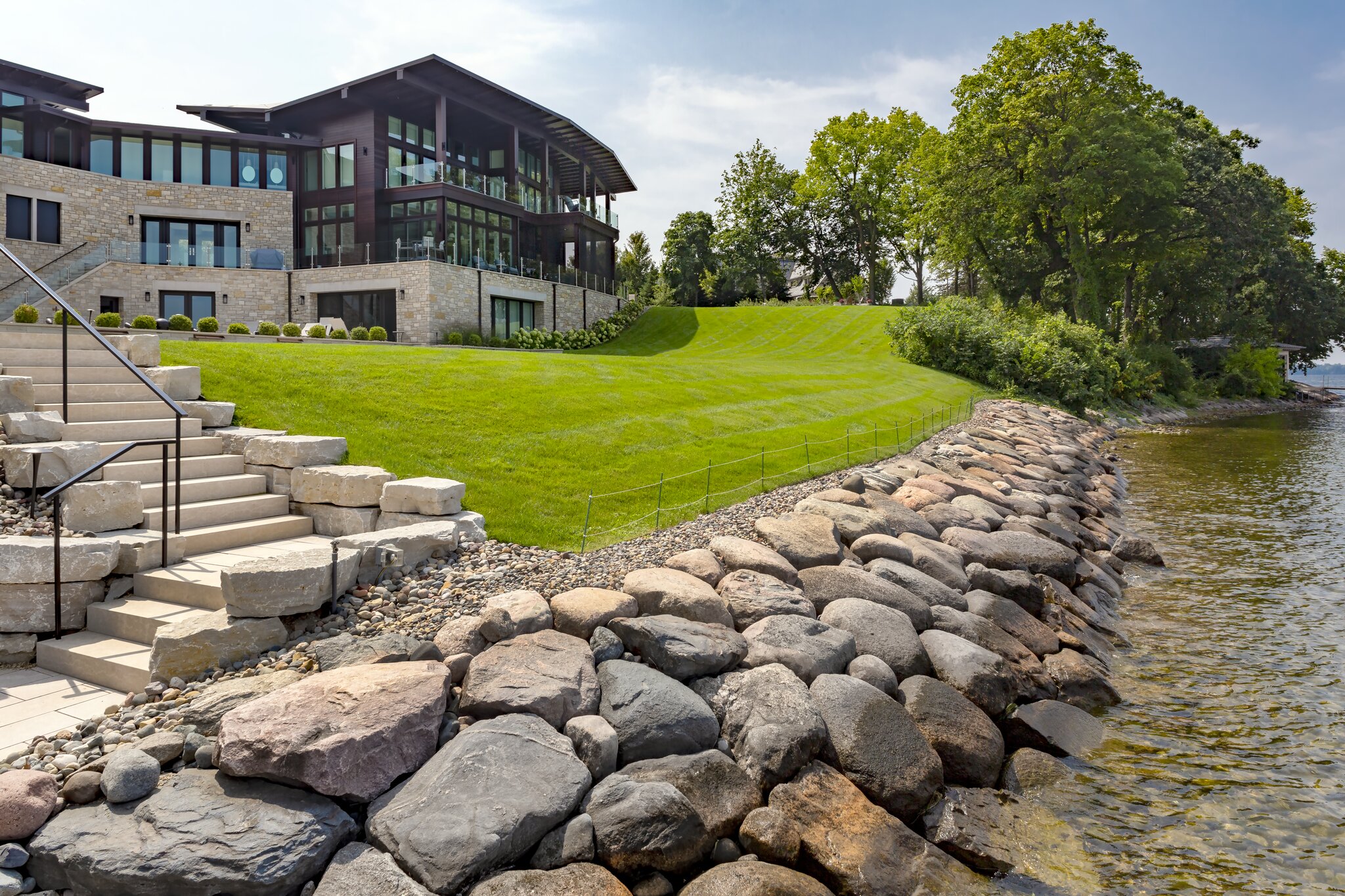 Modern lakeside house with lush green lawn