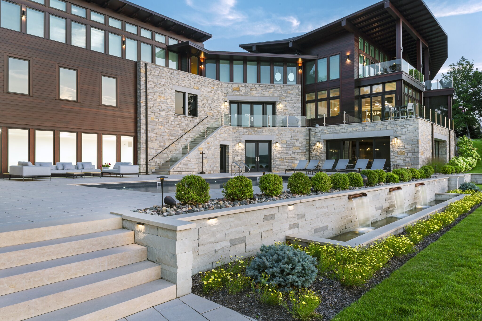Modern luxury house with large windows and garden.