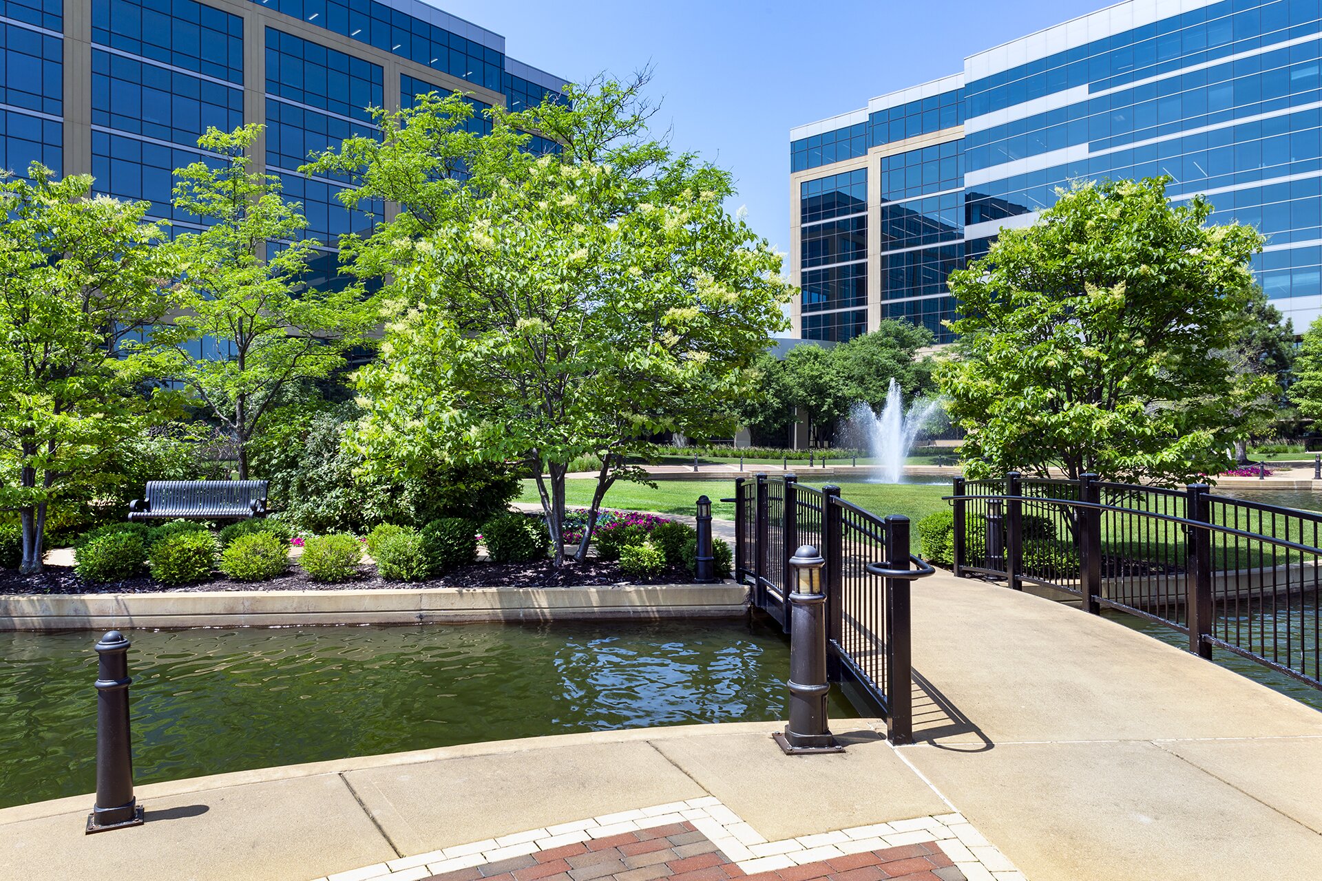 Office park with trees, bridge, and fountain.