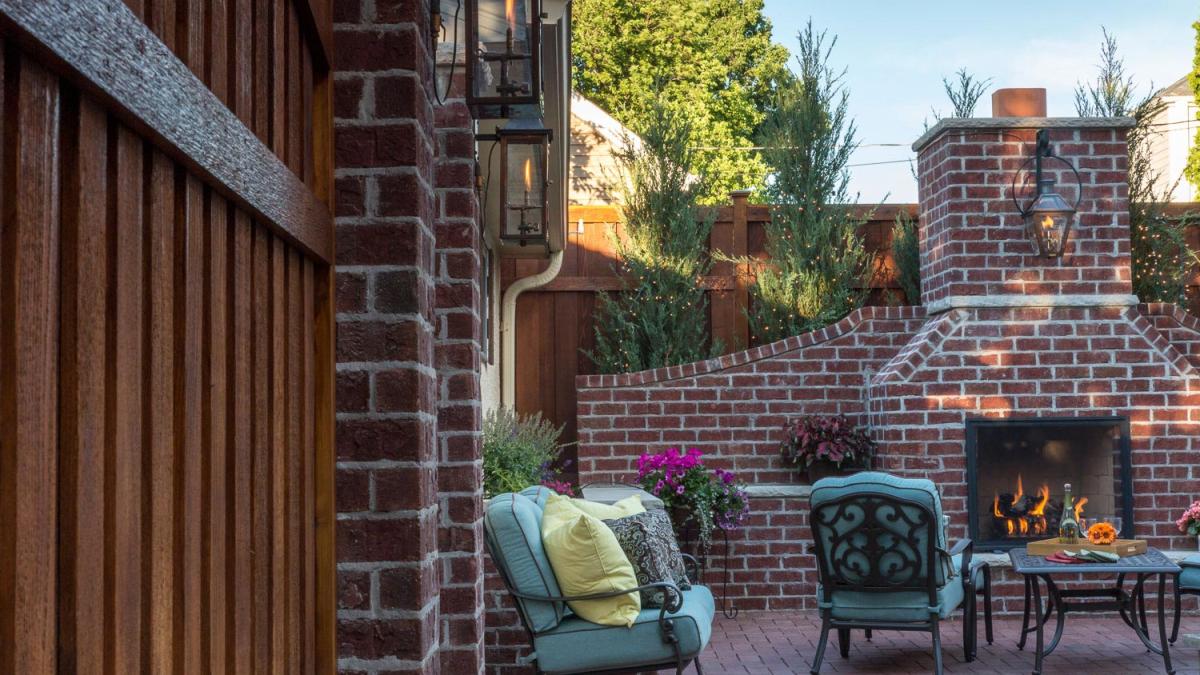 Cozy patio with brick fireplace and seating area.