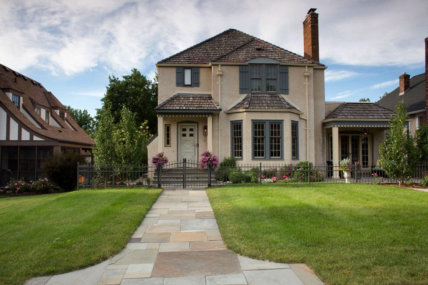Charming two-story house with landscaped front yard.