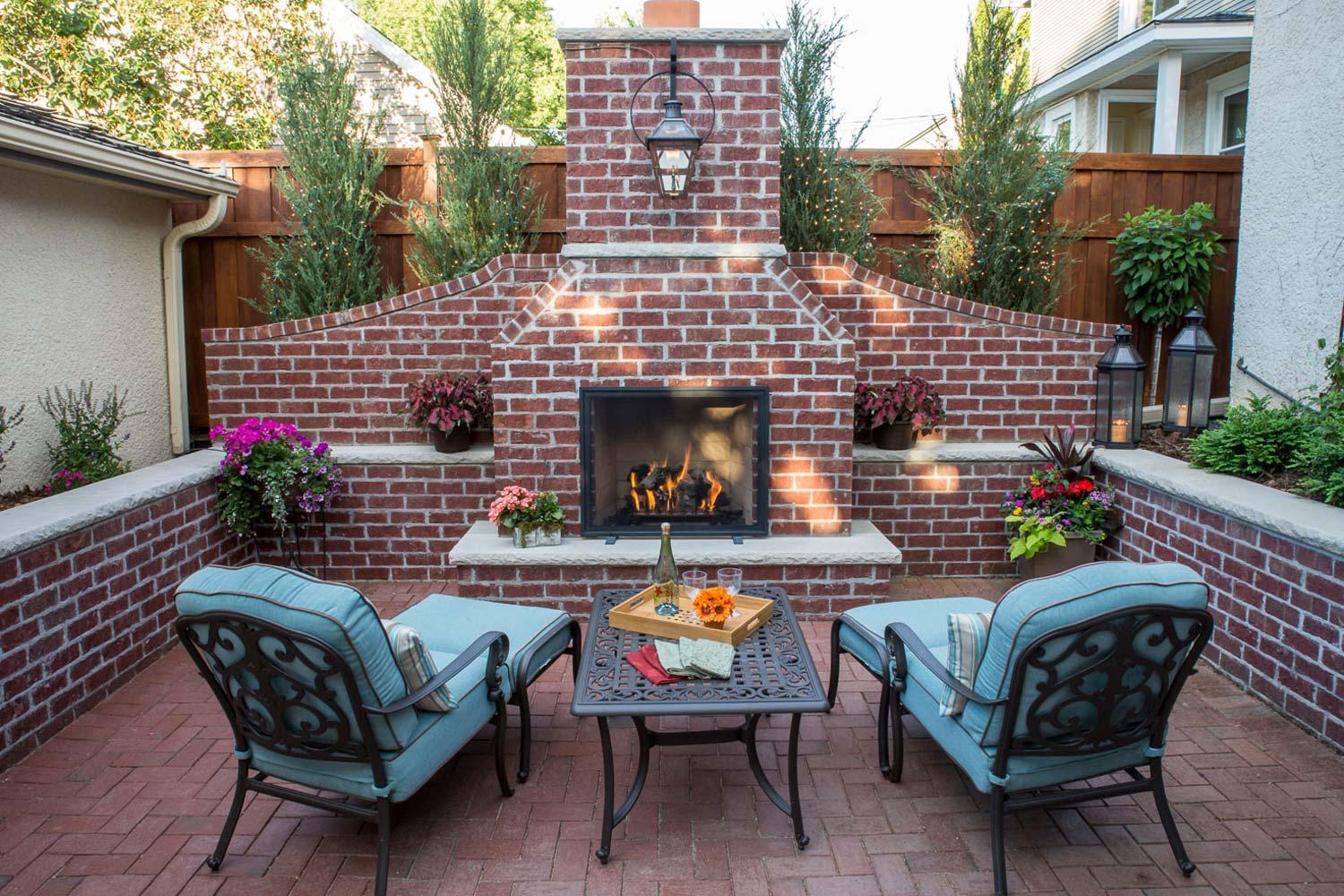 Cozy patio with brick fireplace and seating area.