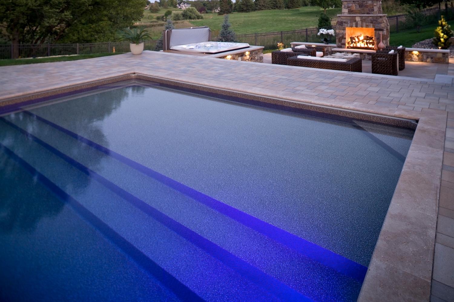 Luxury backyard with pool, hot tub, and fireplace.