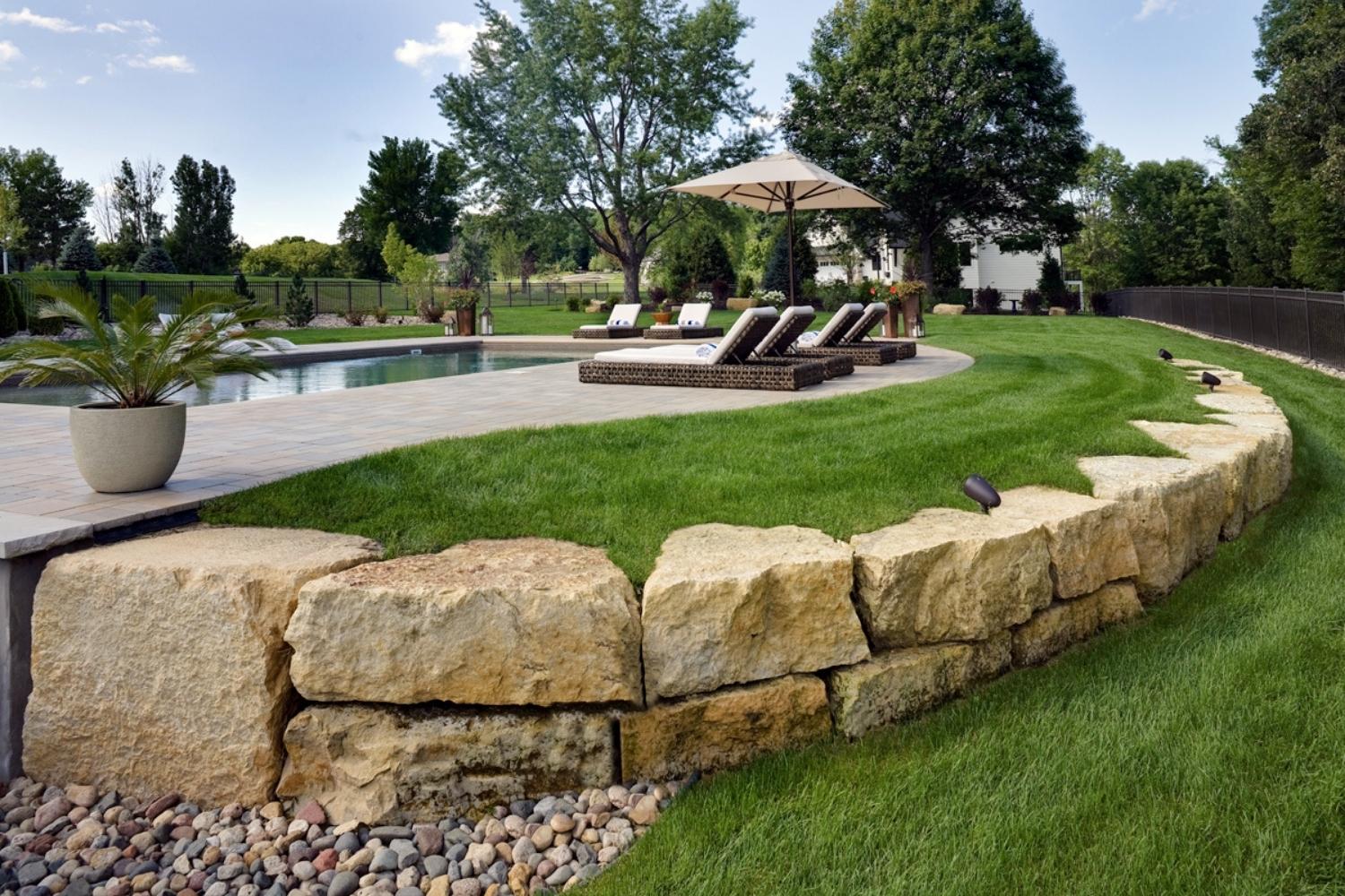 Outdoor pool with lounge chairs and landscaping.