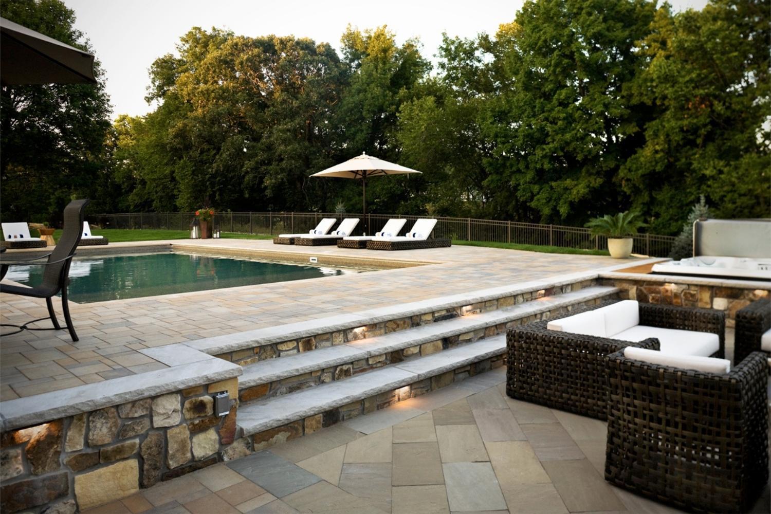 Luxurious backyard with pool and lounge chairs.