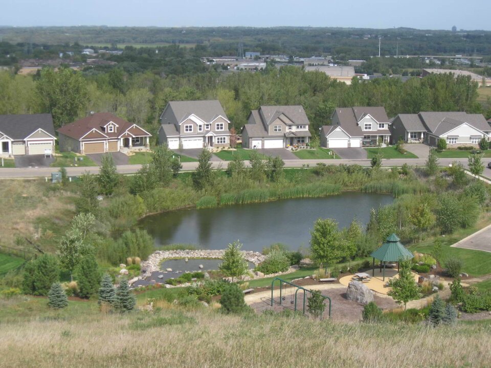Suburban neighborhood with pond and playground area.