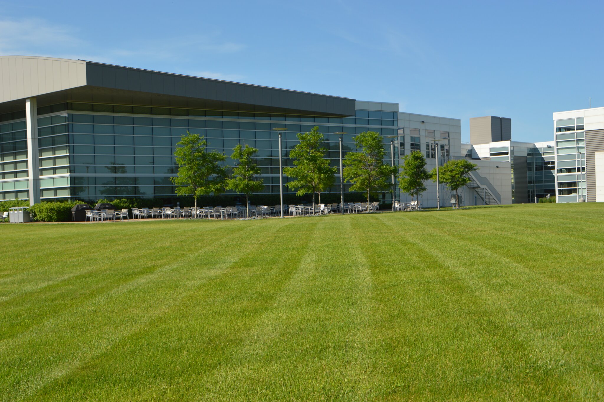 Modern building with glass facade and green lawn.