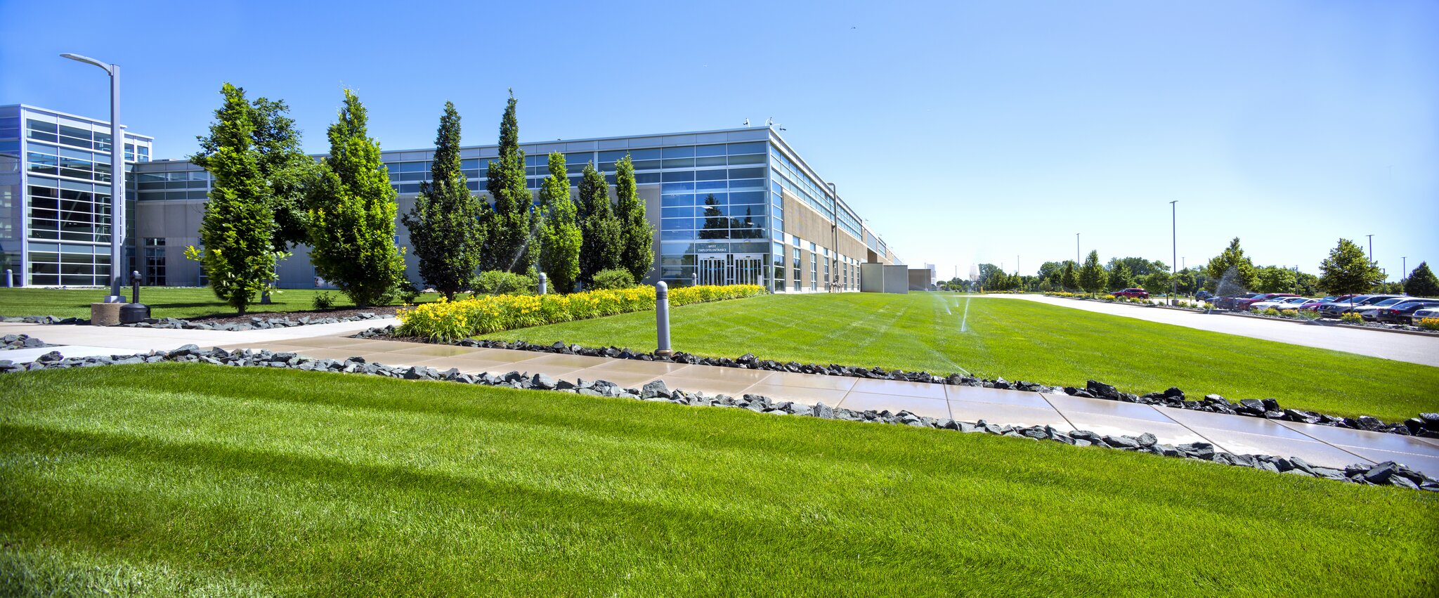 Modern office building with green lawn and trees.