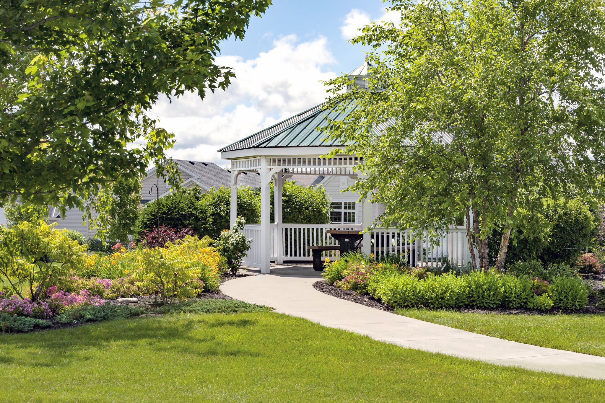 Garden gazebo with greenery and pathway.
