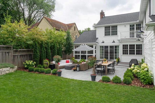 Backyard patio with furniture and garden view.