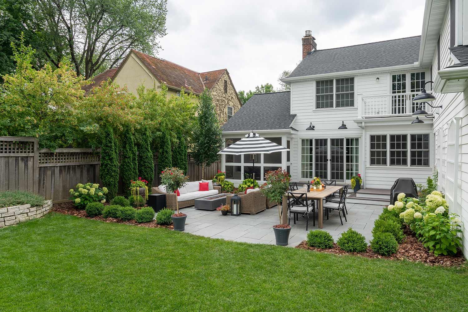 Cozy backyard patio with seating and umbrella.
