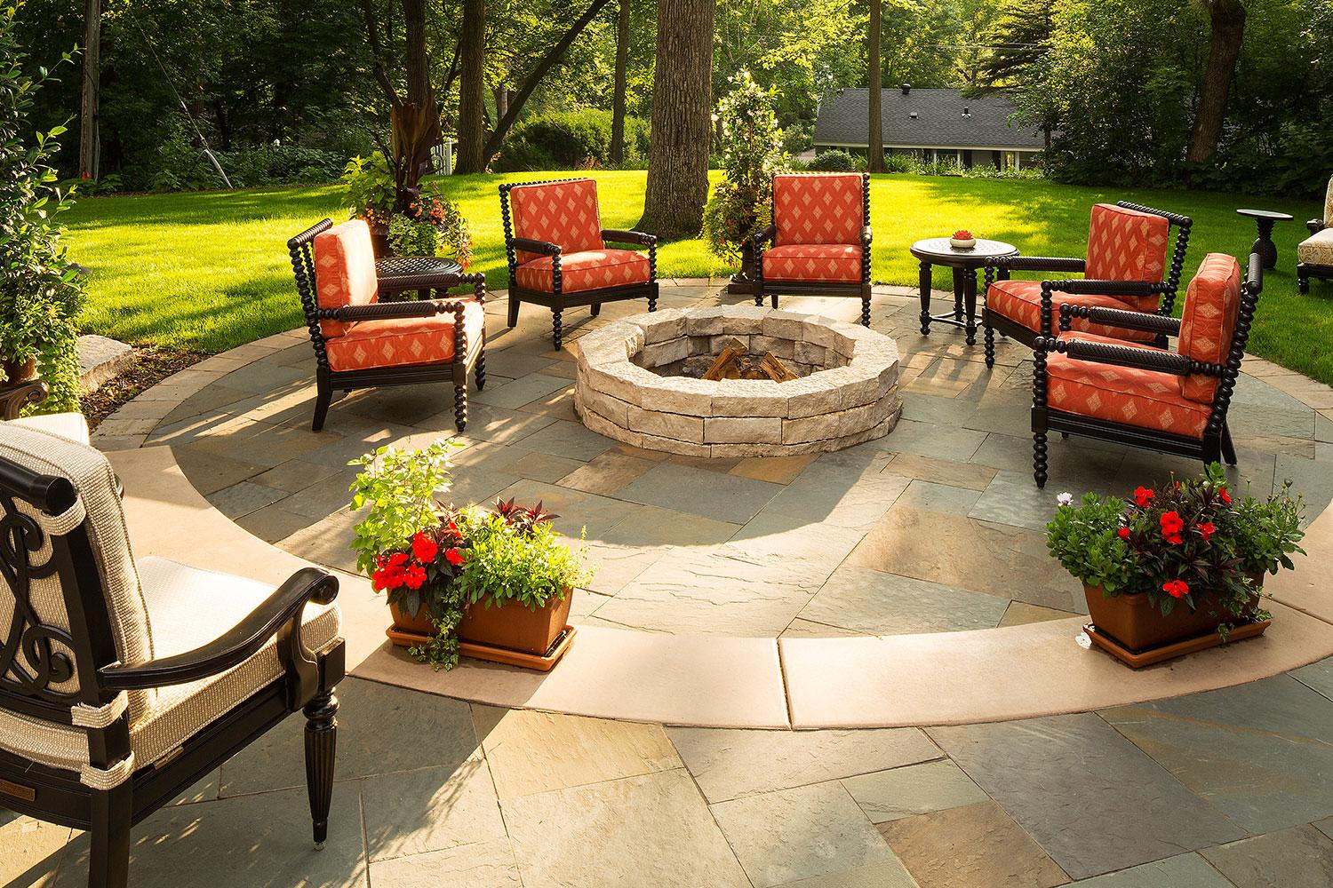 Backyard patio with fire pit and chairs.