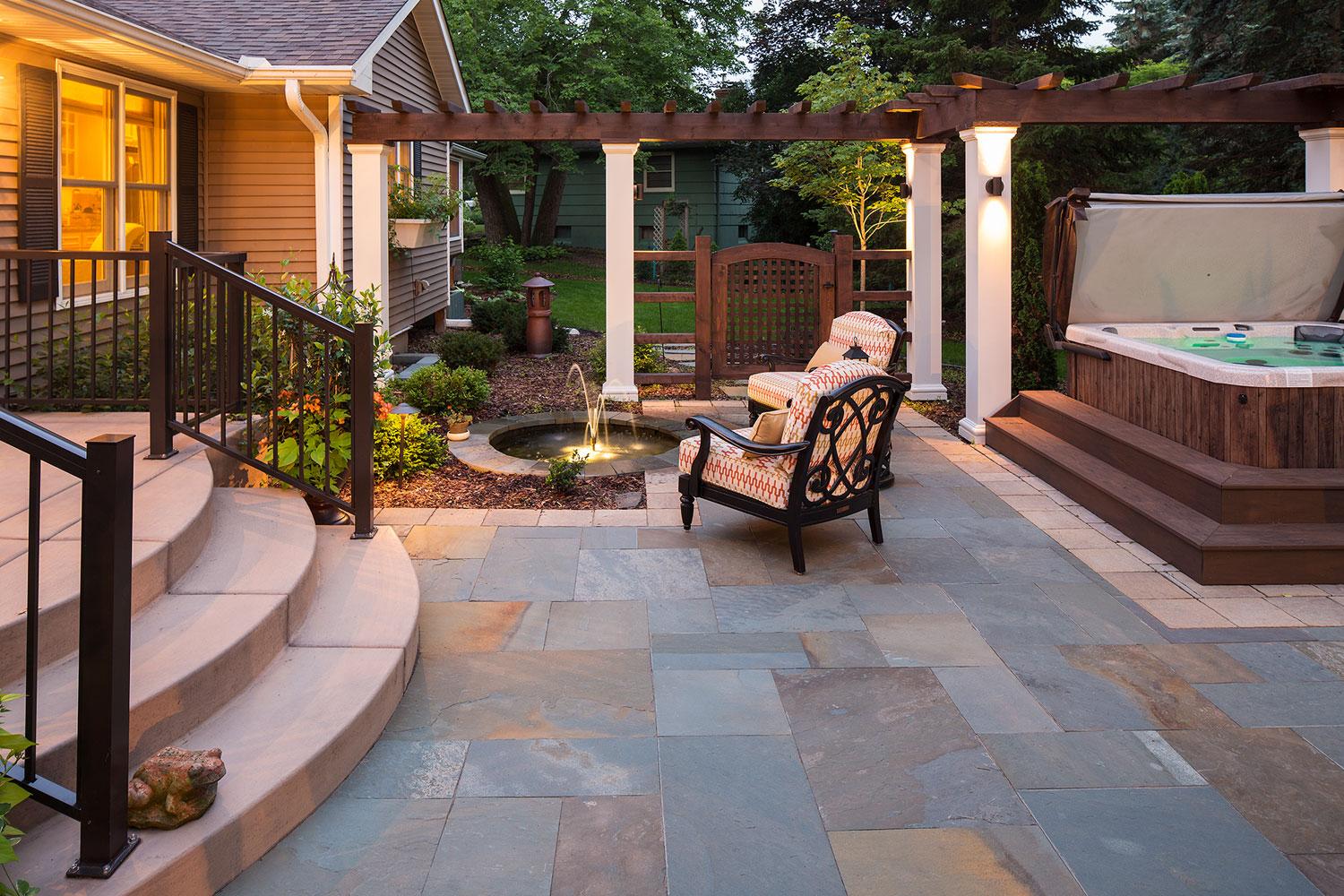 Cozy patio with hot tub and garden fountain.