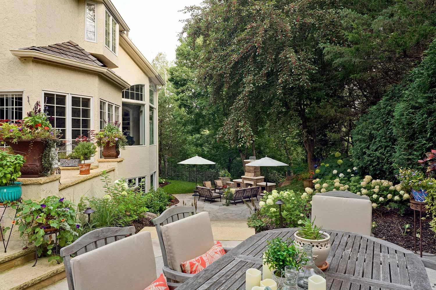 Lush backyard patio with garden and seating area.