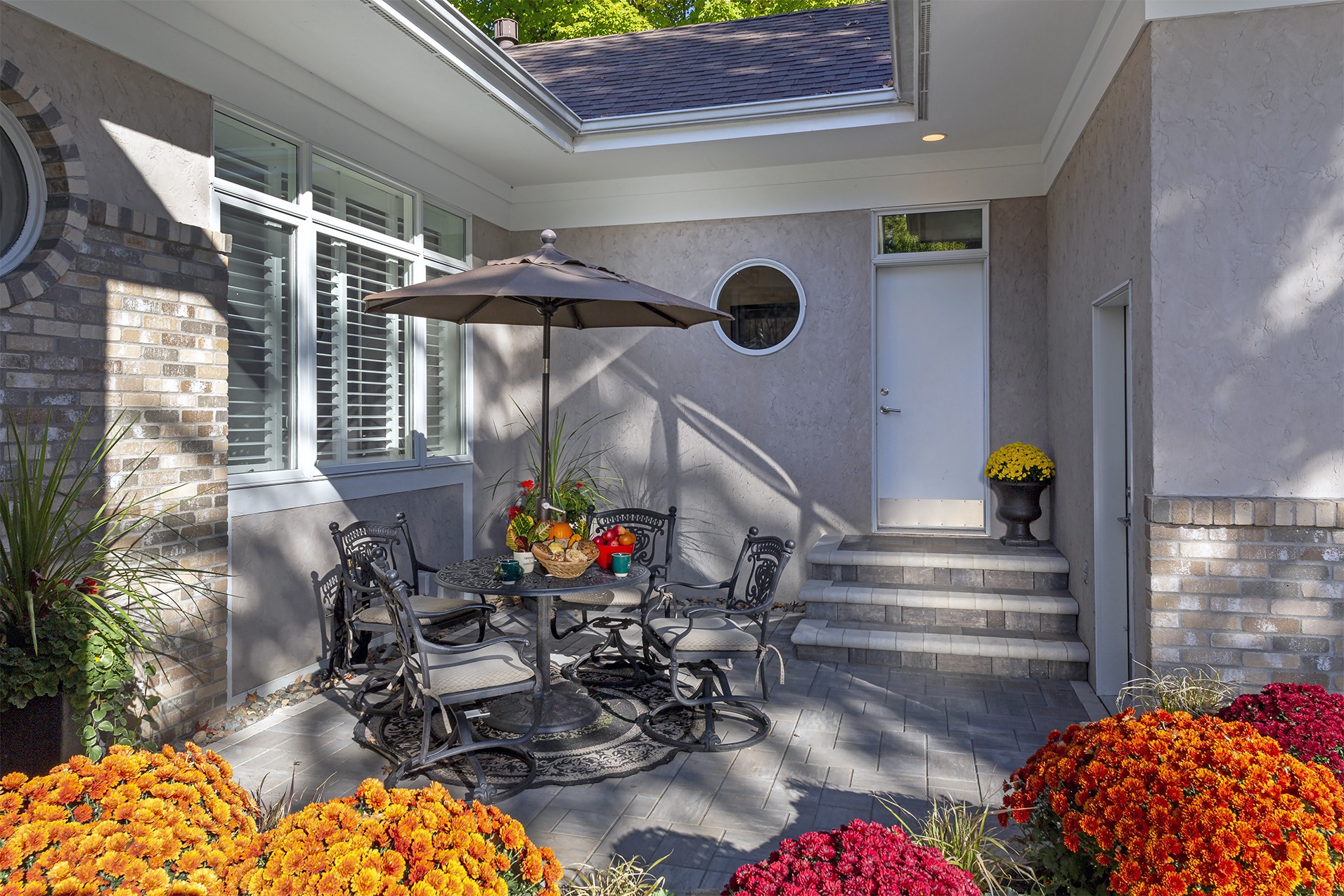 Cozy patio with flowers and outdoor seating.