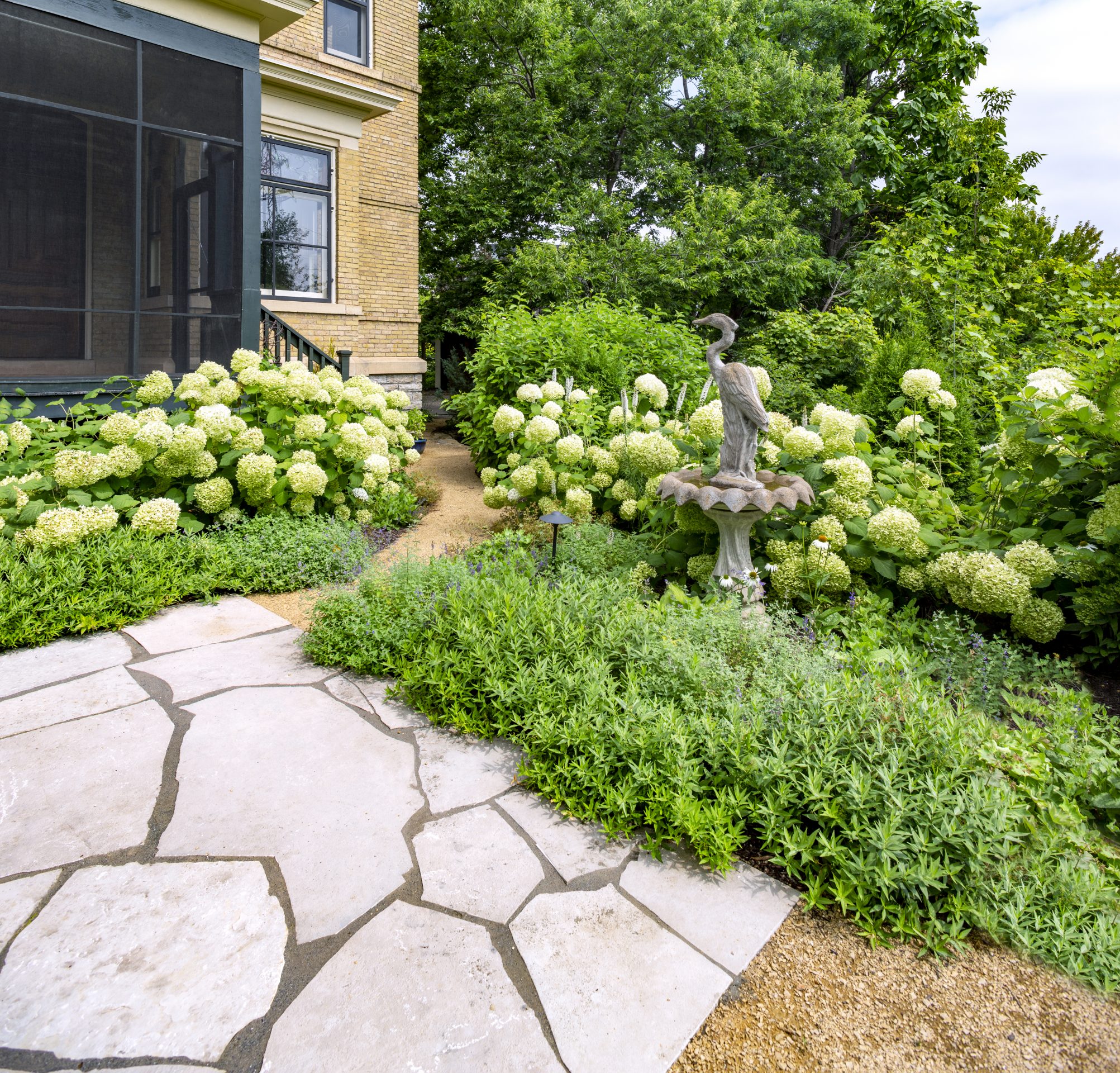 Garden with stone path and bird statue