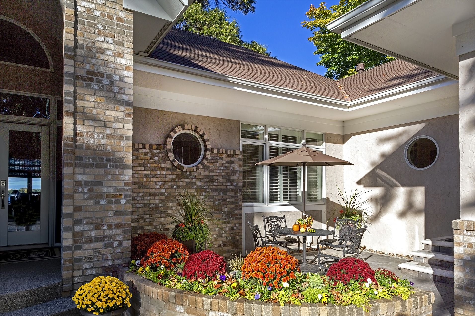 Cozy patio with flowers and outdoor furniture.