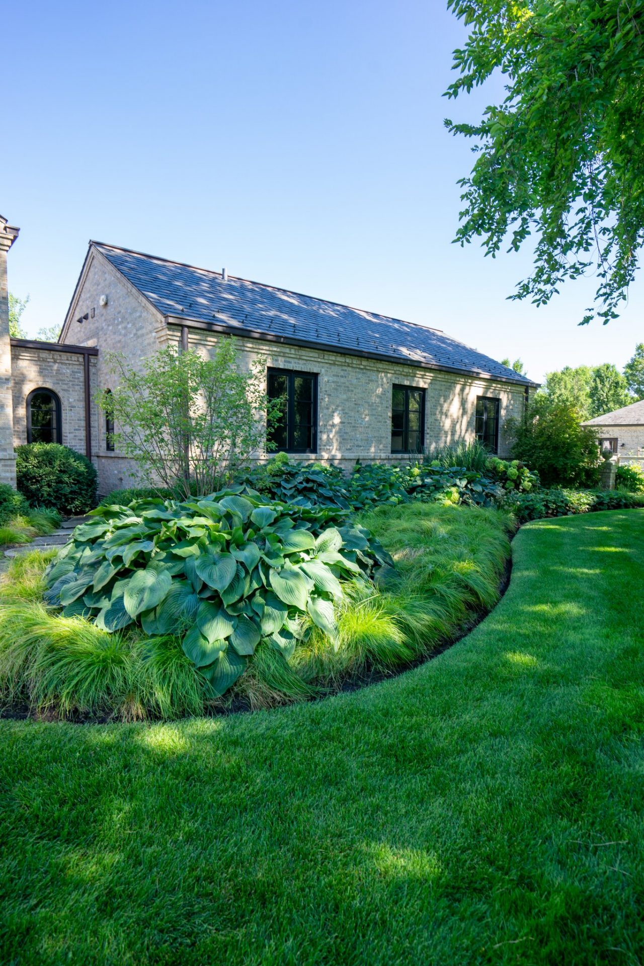 Brick house with lush green landscaping
