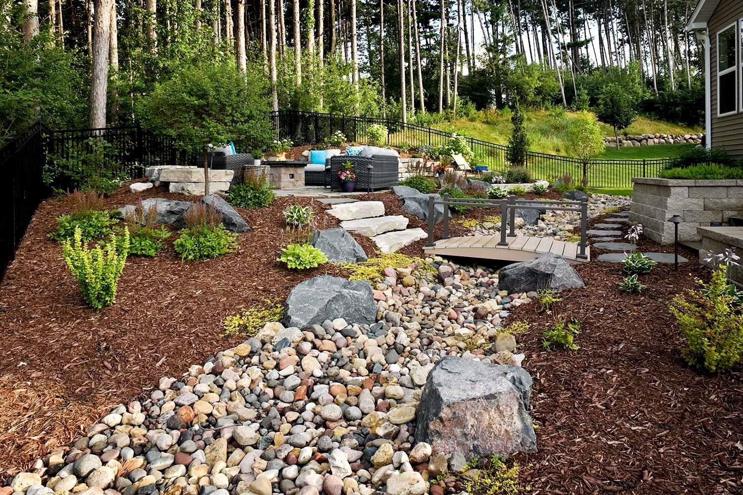 Beautiful landscaped garden with rocks and wooden path.