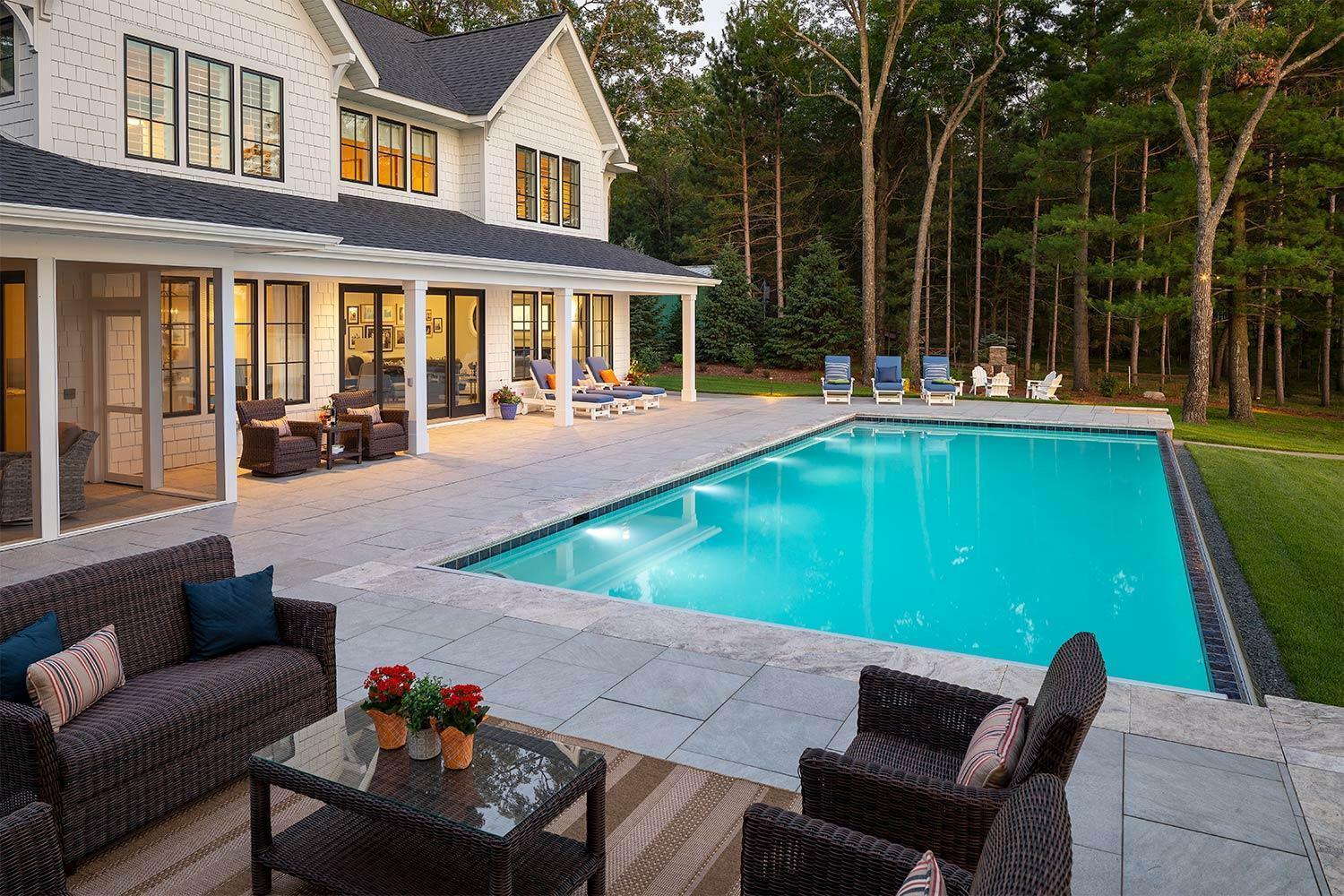 A resort-style backyard featuring a sleek pool, multiple lounge areas, and a seamless indoor–outdoor connection — the perfect example of 2026’s “outdoor rooms” trend.