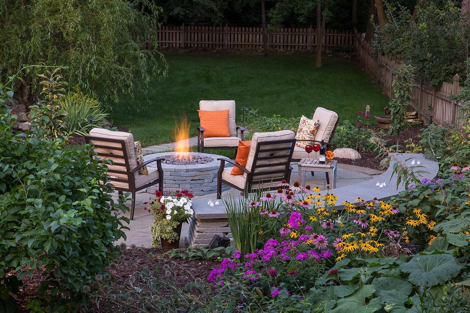 A secluded fire patio surrounded by native perennials and a seat wall.