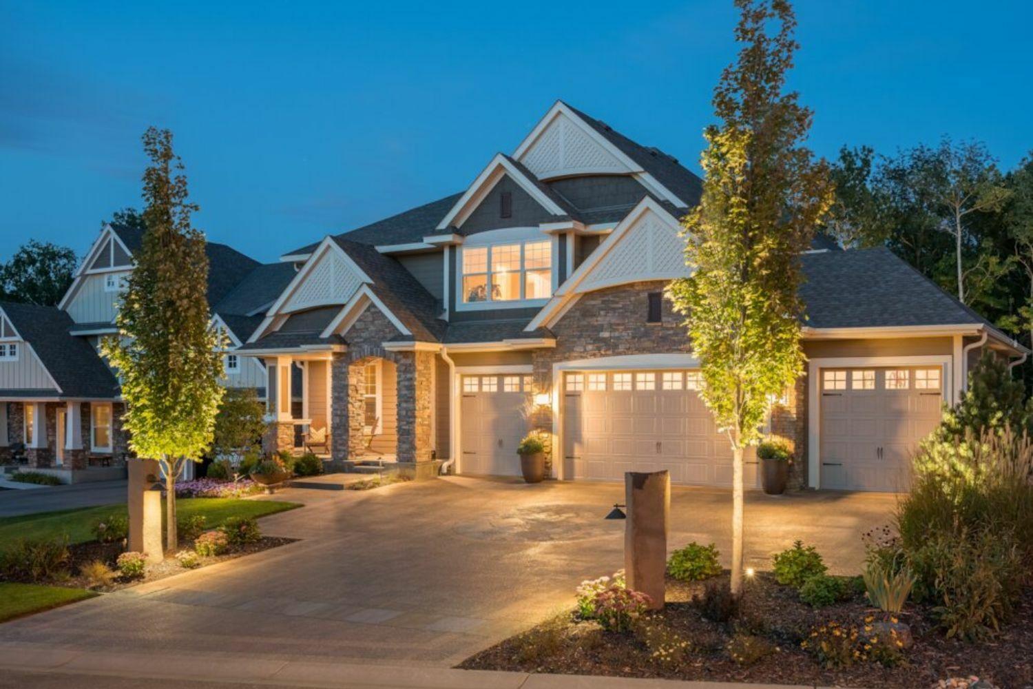 After: The front yard showcases a stunning driveway, vibrant plantings, and thoughtful lighting.