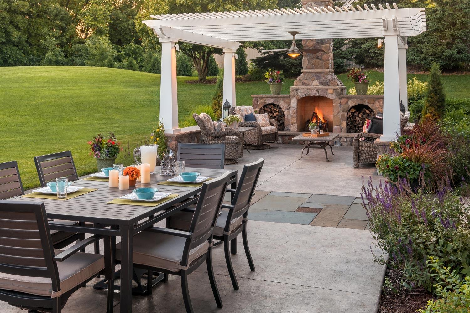 Outdoor patio with pergola, fireplace, and dining area.
