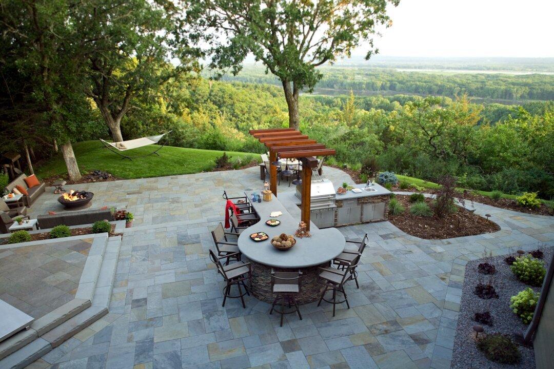 Spacious patio with outdoor kitchen and forest view.