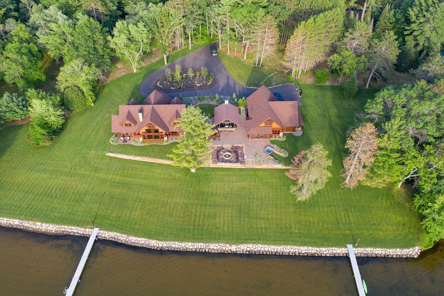 Aerial view of lakeside mansion with dock.