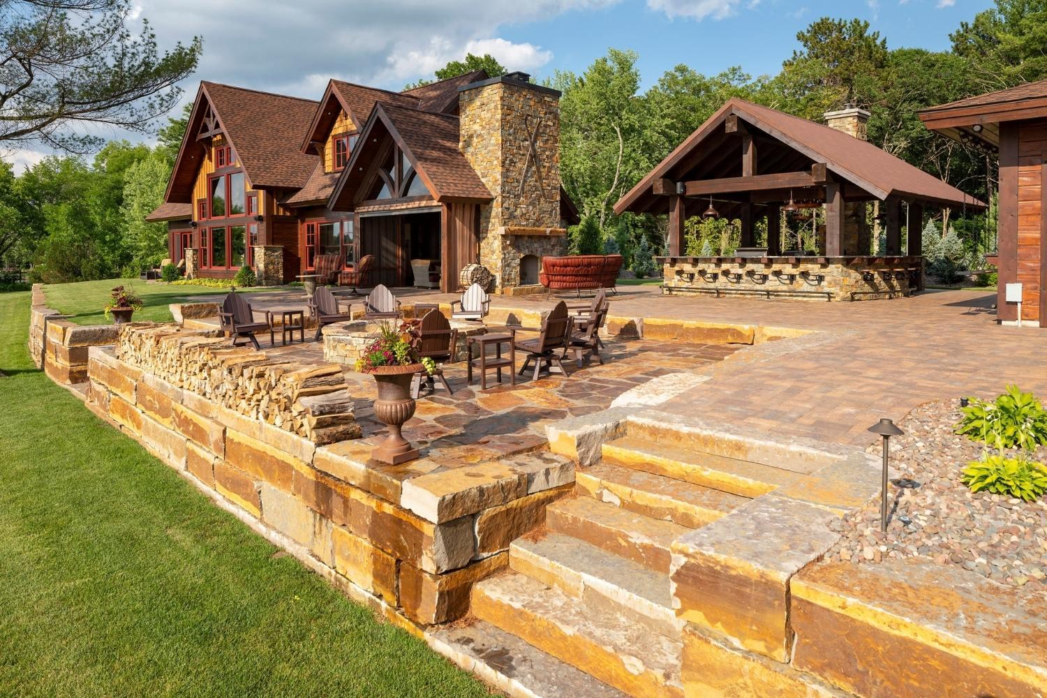 Luxury rustic cabin with spacious patio and seating.