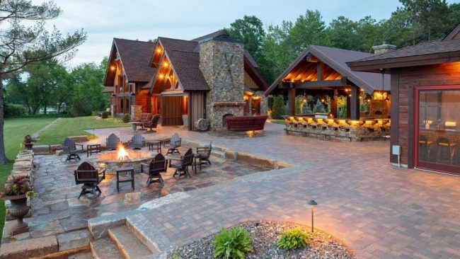 Luxurious lodge with outdoor seating and fire pit.