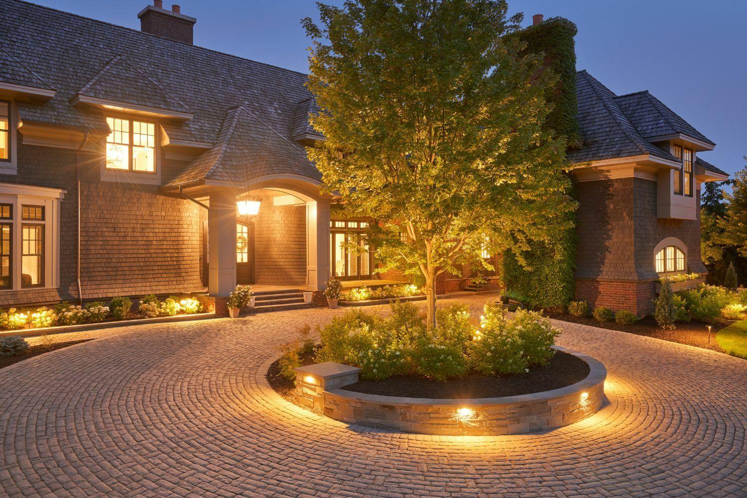 Elegant house with lit driveway at dusk