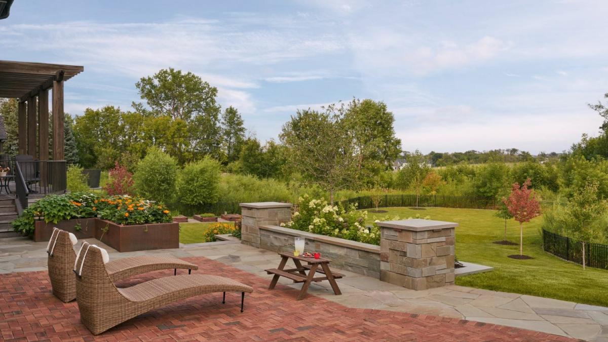 Backyard garden with patio chairs and picnic table.