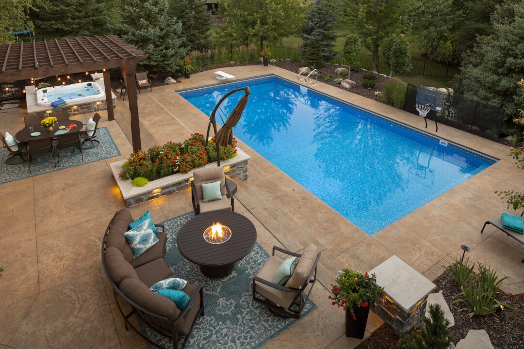 Luxurious backyard with pool, hot tub, and seating area.