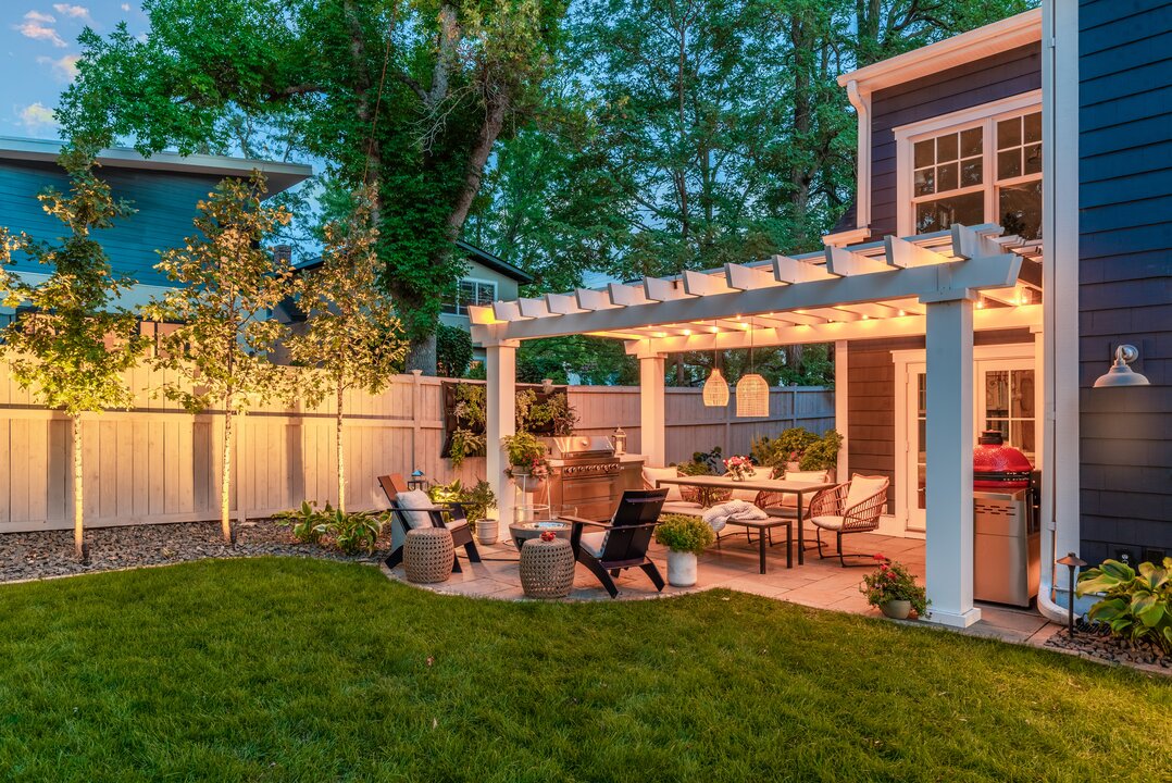 Backyard patio with pergola and outdoor seating area.