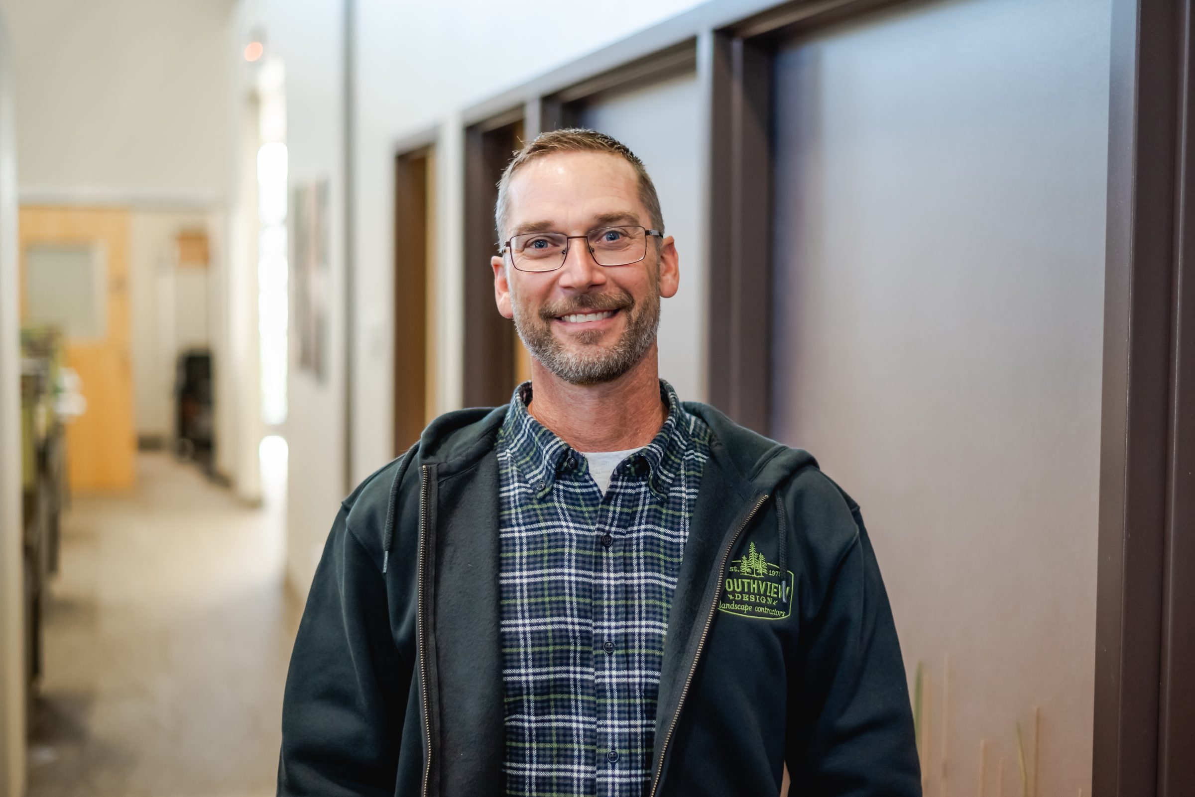 Smiling man in casual attire indoors.